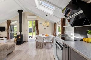 a kitchen and living room with a table and a stove at 1630-Frederiksvaerk-Munkebakken-2 in Frederiksværk +13 photos