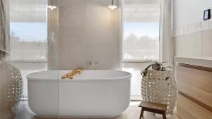 a white bathroom with a tub and a sink at Malmsbury Cottage in Malmsbury
