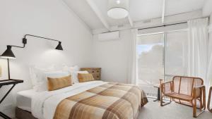 a bedroom with a bed and a large window at Malmsbury Cottage in Malmsbury +19 photos