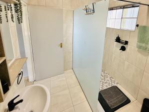 a bathroom with a shower and a sink at Sanctuary Guesthouse in Kimberley +24 photos