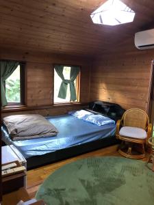 a bedroom with a bed and a chair in a cabin at PrivateVillaHutamiLog in Nago