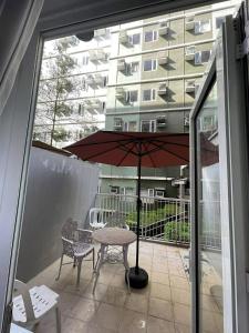 a patio with a table and an umbrella and a building at TuksHotel in Manila