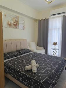 a teddy bear laying on a bed in a bedroom at TuksHotel in Manila