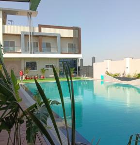 a large swimming pool in front of a building at The Water Box in Kānpur
