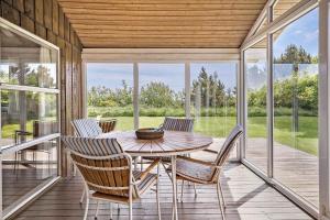 a porch with a wooden table and chairs on it at 40703-Ulfborg-Helmklit-227 in Ulfborg