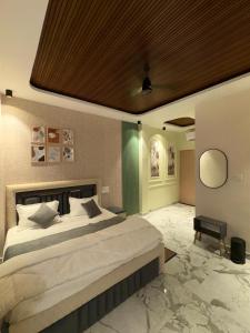 a bedroom with a large bed with a wooden ceiling at The Water Box in Kānpur
