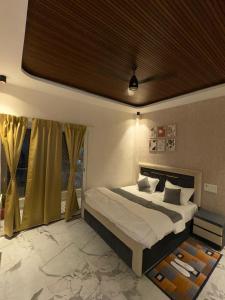 a bedroom with a large bed and a window at The Water Box in Kānpur