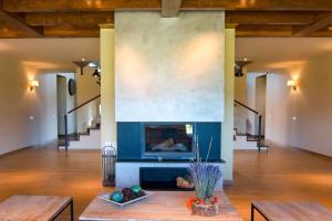 a living room with a fireplace and two benches at Casa de 7 suites y vistas 360. Les Feixes Llargues in Bolvir