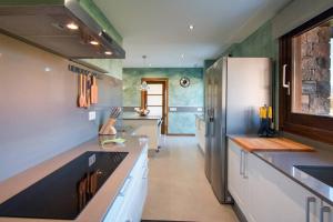 a kitchen with white cabinets and a refrigerator at Casa de 7 suites y vistas 360. Les Feixes Llargues in Bolvir