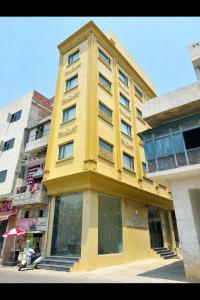 a yellow building on the side of a street at Hotel RK Heights 300M HOTEL TO GOLDEN TEMPLE in Amritsar