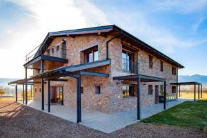 a brick house with a balcony on the side of it at Casa de 7 suites y vistas 360. Les Feixes Llargues in Bolvir