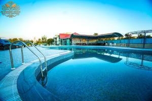 a large swimming pool in front of a building at Jai Ganesha Resort in Chālsa Mahābāri