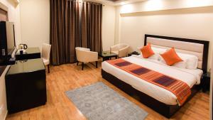 a hotel room with a bed and a desk at Starz Clarks INN Mussoorie in Mussoorie +13 photos