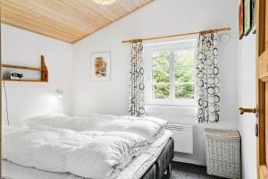a bedroom with white walls and a bed with pillows at 10831-Ulfborg-Graemvej-57 in Ulfborg