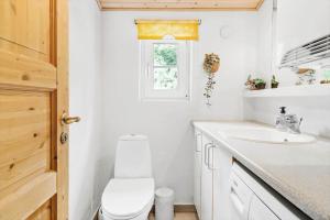 a bathroom with a toilet and a sink and a window at 10831-Ulfborg-Graemvej-57 in Ulfborg