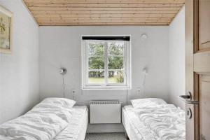 two beds in a room with a window at 30859-Ulfborg-Bellisvej-432 in Ulfborg