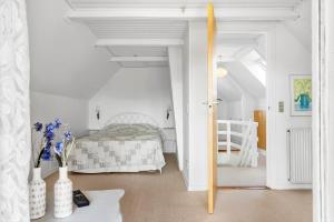 a bedroom with a bed in a white room at 70303-Ulfborg-Jagtvejen-4 in Ulfborg