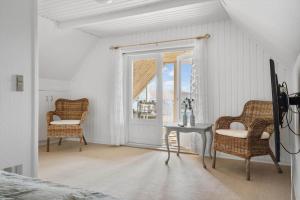 a bedroom with a bed and a table and chairs at 70303-Ulfborg-Jagtvejen-4 in Ulfborg