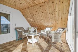a patio with a glass table and chairs at 70303-Ulfborg-Jagtvejen-4 in Ulfborg