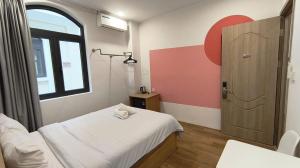 a room with a bed and a window and a door at LokoOne Central Hub in Hòa Bình