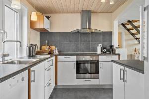 a kitchen with white cabinets and a sink at 70029-Ulfborg-Vesterhavsgade-6 in Ulfborg