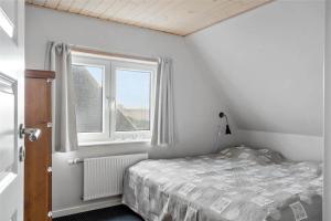 a small bedroom with a bed and a window at 70029-Ulfborg-Vesterhavsgade-6 in Ulfborg