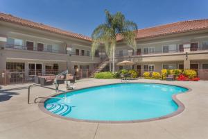 a swimming pool in front of a building at Baymont by Wyndham Modesto Salida in Modesto