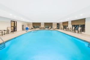 a large pool in a hotel with chairs and tables at Wingate by Wyndham Niagara Falls in Niagara Falls