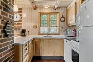 a kitchen with wooden cabinets and a brick wall at 10019-Ulfborg-Gaffelbjergvej-18 in Ulfborg