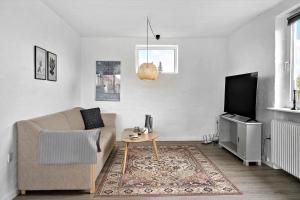 a living room with a couch and a tv at 70099-Ulfborg-Klitrosevej-2 in Ulfborg