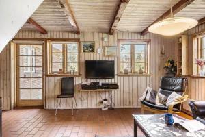 a living room with a flat screen tv and chairs at 10019-Ulfborg-Gaffelbjergvej-18 in Ulfborg