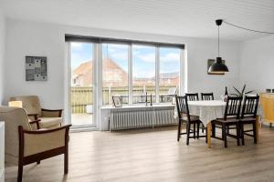 a living room with a table and chairs and a large window at 70099-Ulfborg-Klitrosevej-2 in Ulfborg