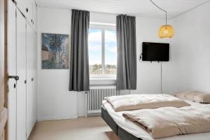 a bedroom with two beds and a flat screen tv at 70099-Ulfborg-Klitrosevej-2 in Ulfborg