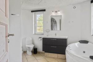 a bathroom with a tub and a sink and a toilet at 30876-Ulfborg-Krogsgardvej-5 in Ulfborg +16 photos