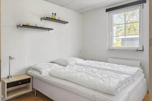 a white bedroom with a bed and a window at 30876-Ulfborg-Krogsgardvej-5 in Ulfborg