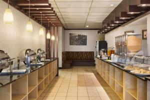 a restaurant with a long counter with a bench at Days Inn by Wyndham Vermilion in Vermilion