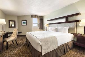 a hotel room with a large bed and a desk at Days Inn by Wyndham Vermilion in Vermilion +58 photos