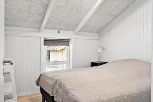 a white bedroom with a bed and a window at 30134-Ulfborg-Klovervej-475 in Ulfborg