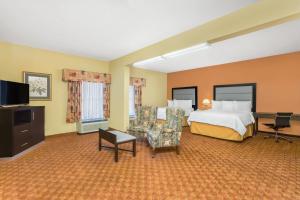 a hotel room with a bed and a desk at Baymont by Wyndham Fayetteville in Fayetteville +25 photos