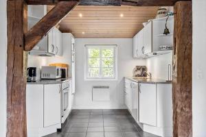 a kitchen with white cabinets and a window at 10706-Ulfborg-Graevlingevej-3 in Ulfborg +15 photos