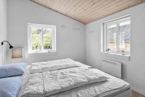 a white bedroom with a bed and two windows at 10706-Ulfborg-Graevlingevej-3 in Ulfborg