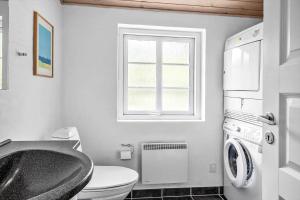 a bathroom with a sink and a toilet and a window at 10706-Ulfborg-Graevlingevej-3 in Ulfborg
