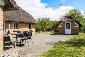 a patio with a table and chairs in front of a building at 10706-Ulfborg-Graevlingevej-3 in Ulfborg