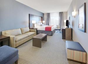 a hotel room with a bed and a couch at Wingate by Wyndham San Angelo in San Angelo
