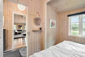 a bedroom with wooden walls and a bed in a room at 30121-Ulfborg-Klovervej-474 in Ulfborg