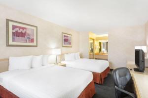 a hotel room with two beds and a television at Days Inn by Wyndham Bullhead City in Bullhead City +32 photos