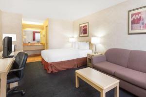 a hotel room with a bed and a couch at Days Inn by Wyndham Bullhead City in Bullhead City
