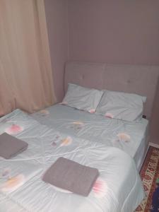 a bed with two towels and pillows on it at Sumud Bonda Homestay in Kuala Kerai +8 photos
