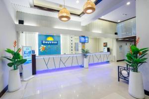 a lobby with a dgas sign and potted plants at Days Inn by Wyndham Patong Beach in Patong Beach