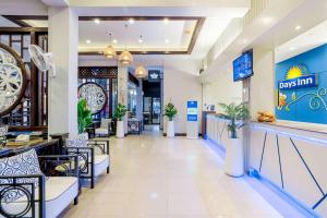 a lobby of a restaurant with a clock on the wall at Days Inn by Wyndham Patong Beach in Patong Beach